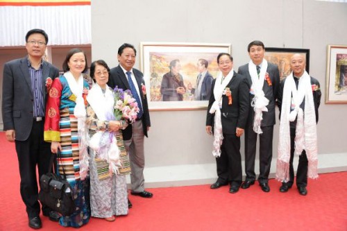 Fotografia do pessoal de direcção do Tibete e os membros da delegação à frente das obras expostas